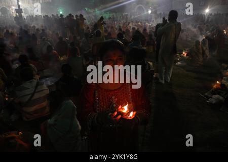 Kalkutta, Westbengalen, Indien. November 2024. Hindugeweihte sitzen zusammen vor Öllampen und beten zu Shri Shri Loknath Brahmachari, einem hinduheiligen und Philosophen, während sie das Rakher Upobash Festival beobachten, in einem Tempel in Chakla Dham und Tempel etwa 69 km nördlich von Kolkata, Indien, am 16. November 2024.Hindufrauen beobachten ein eintägiges Fasten und Gebete während des ''Kartik Brata' oder ''Rakher Upobash' oder ', um ihre Kinder zu heilig zu sein und Wohlgefallen. und die Reinigung ihrer eigenen Körper und Seelen. (Bild: © Rupak de Chowdhuri/ZUMA Press Wire) EDITORI Stockfoto