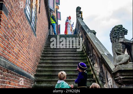 Nijmegen, Niederlande. November 2024. Der Nikolaus begrüßt einige Kinder, die am Ende der Treppe stehen. Am ersten Samstag nach dem 11. November trifft die rot-weiß-bekleidete Sinterklaas (St. Nikolaus) in mehreren niederländischen Städten ein. In Nijmegen ging Sinterklaas auf einer Route durch das Stadtzentrum, begleitet von seinen Helfern, dem Pieten (Peters), der Kindern und Erwachsenen traditionelle Süßigkeiten schenkte. (Foto: Ana Fernandez/SOPA Images/SIPA USA) Credit: SIPA USA/Alamy Live News Stockfoto