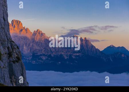 Berge über den Wolken atemberaubende Landschaft. Hohe felsige Gipfel, die sich durch Nebel erheben, machen diese Szene dramatische Blicke aus großer Höhe mit weichen Wolken Stockfoto