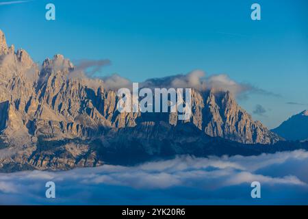 Berge über den Wolken atemberaubende Landschaft. Hohe felsige Gipfel, die sich durch Nebel erheben, machen diese Szene dramatische Blicke aus großer Höhe mit weichen Wolken Stockfoto