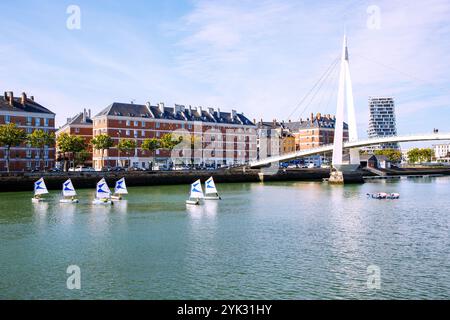 Bassin du Commerce mit Fußgängerbrücke Passerelle de la Bourse und Trainingsbooten der Segelschule, Blick auf die Appartementhäuser von Auguste Perret Stockfoto