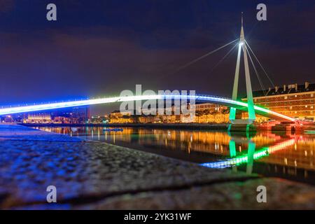 Bassin du Commerce mit Wasserreflexion und Fußgängerbrücke Passerelle de la Bourse mit farbiger Beleuchtung im Abendlicht in Le Havre auf der A Stockfoto