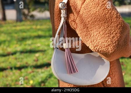 Frau mit rosa Leder Schlüsselanhänger an ihrer Tasche draußen, Nahaufnahme Stockfoto