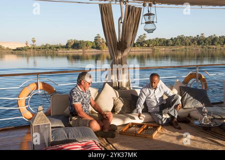 Zwei Passagiere spielen Backgammon auf dem Oberdeck einer Dahabeah, Passagierschiff der Lazuli-Flotte, segeln auf dem Nil, Ägypten, Northeas Stockfoto