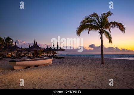 Fischerboot, Strohschirme und Kokospalmen am Strand des Dinarobin Beachcomber Golf Resort Stockfoto