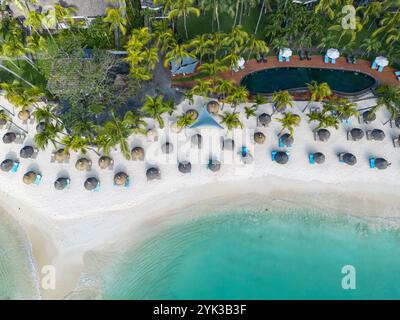 Blick aus der Vogelperspektive auf die Strohschirme am Strand von Royal Palms Beachcomber Luxury (Beachcomber Resorts), Grand Baie, Rivière du Rempart, Mauritius, Ind Stockfoto