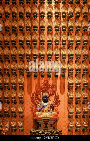 Weitwinkelblick auf die blaue Acala Vidyaraja Gottheit Statue umgeben von einer Wand aus kleineren, komplizierten Götterfiguren im Buddha-Zahn-Relikt-Tempel, dem berühmten Trav Stockfoto