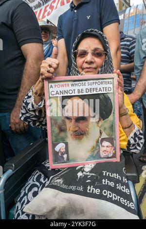 London, Großbritannien. Juni 2017. Eine Frau im Rollstuhl hält gerahmte Porträts der Ayatollah auf dem jährlichen Al Quds (Jerusalem) Day march in London, an dem mehrere Tausend aus dem ganzen Land teilnahmen. Organisiert vom Quds-Komitee mit der Islamischen Menschenrechtskommission und unterstützt von verschiedenen Gruppen, darunter der Stop the war Coalition, der Muslim Association of Britain and Jews für den Boykott israelischer Güter, wurde es von Imamen und Neturei Karta-antizionistischen Juden geleitet und forderte Freiheit für Palästina und für alle unterdrückten Menschen auf der ganzen Welt. Wie üblich zog er Opposition von zionistischer Gr Stockfoto