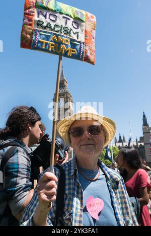 London, Großbritannien. Juni 2017. Eine Frau hält bei der Kundgebung auf dem Parliament Square ein gesticktes Plakat „No to Rassiism No to Trump“ hoch, mit Reden, Musik und Tanz, um die bemerkenswerte Leistung zu feiern, die Labour unter Jeremy Corbyn bei den Parlamentswahlen gemacht hat. Sie fordern Unterstützung für ihn innerhalb und außerhalb der Labour Party, den Kampf für die Werte der Labour-Partei fortzusetzen und alle Labour-Abgeordneten hinter einen Führer zu stellen, der gezeigt hat, dass er die Labour-Stimmen erhöhen kann. Redner forderten Theresa May auf, zu gehen, und äußerten ihre Abscheu darüber, dass sie einen Pakt mit der rechtsextremen DUP mit ITS geschlossen habe Stockfoto