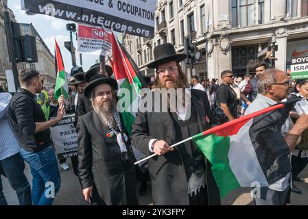 London, Großbritannien. Juni 2017. Die Demonstranten des Al-Quds-Tages stehen auf, nachdem sie sich verspätet haben und eine Minute Schweigen über den Grenfell-Turm halten, während sie darauf warten, dass die Polizei die Zionisten von ihrem Weg entfernt. Die Polizei hatte die Zionisten nur ein paar Meter die Oxford Street hinunter gebracht, aber die Demonstranten machten deutlich, dass sie den marsch - sehr viel ein Familienereignis - durch sie nehmen würden, wenn die Polizei die Straße nicht frei machen würde. Die Polizei brachte die Zionisten langsam auf die Straße, während die Al-Quds-Demonstranten dahinter folgten. Stockfoto