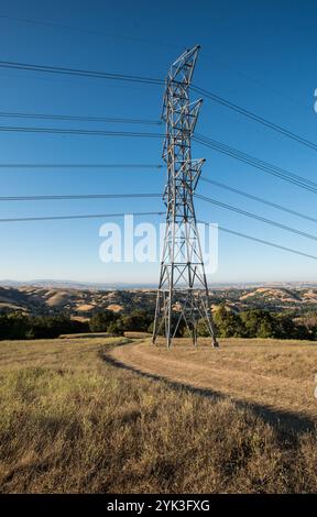 Hochspannungs-Stromleitungen und -Türme ziehen sich am Freitag, den 24. Juli 2015, über viele Bereiche des 6.255 Hektar großen East Bay Regional Park District im Briones Regional Park District (http://www.ebparks.org/parks/briones) in Contra Costa County, KALIFORNIEN. Der Kostenanteil-Rancher des US-Landwirtschaftsministeriums Ned Woods installiert Solarpaneele, um Solarenergie für elektrische Brunnenpumpen zu nutzen, die Wasser aus Hunderten von Fuß unter der Oberfläche ziehen und das Wasser entlang kilometerlanger Rohrleitungen in Hunderte Höhengebühren zu einem System aus automatisierten Fernbewässerungsrinnen und -Grou schieben Stockfoto