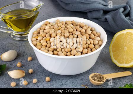 Zutaten für klassischen Hummus: Kichererbsen, Olivenöl, Petersilie, Zitrone, Knoblauch auf blauem Hintergrund. Arabische und türkische Küche Stockfoto