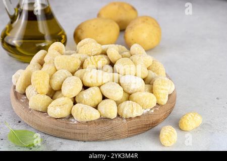 Ungekochte italienische Kartoffelgnocchi auf grauem Hintergrund mit Zutaten. Italienisches Essen. Stockfoto