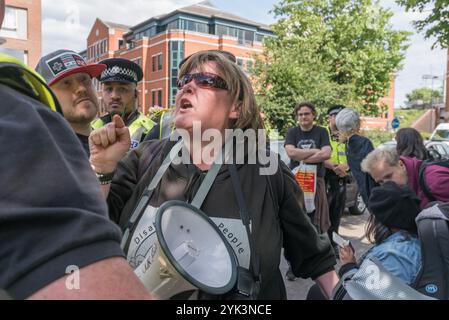 Maidenhead, Großbritannien. Juni 2017. Die Polizei umgibt Menschen mit Behinderungen gegen Schnitte Demonstranten, die eine Hauptstraße in die Stadt blockieren, um im Wahlkreis Theresa May&#8217 gegen die Tory-Regierung zu protestieren, die weltweit die erste Regierung, die der schweren und systematischen Menschenrechtsverletzungen von Behinderten durch die UNO für schuldig befunden wurde, und sagt ihnen, dass sie von der Straße gehen müssen. Paula Peters lässt die Polizei wissen, was sie von ihnen hält, nachdem sie sie mit der Verhaftung bedroht hat, damit sie von der Straße wegzieht. Die seit 2010 vorgenommenen Kürzungen hatten neunmal so viele Auswirkungen auf behinderte Menschen wie andere Stockfoto