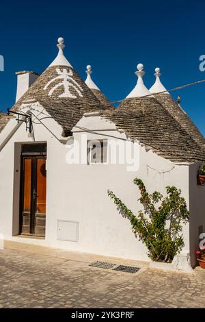 Trulli Häuser mit Symbolen auf den Dächern in Alberobello, Apulien, Italien. Stockfoto