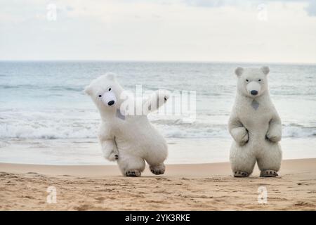Animateure, die als Eisbären verkleidet sind, unterhalten die Leute am Strand Stockfoto