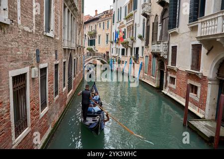 Venedig,Italien;Oktober,17,2024: Ein schmaler Kanal in Venedig, Italien, wo elegante Gondeln mühelos durch ruhiges Wasser gleiten. Die ruhige Oberfläche Stockfoto