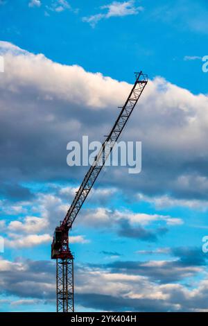 Ein hoch aufragender Baukran, der Materialien auf einer Baustelle hebt Stockfoto