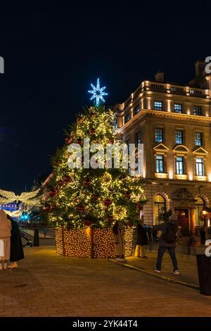 LONDON - 15. NOVEMBER 2024: Schöner Weihnachtsbaum am Waterloo Place gegenüber dem Sofitel Hotel St James's ist in Rot und Gold dekoriert Stockfoto