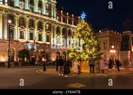 LONDON - 15. NOVEMBER 2024: Schöner Weihnachtsbaum am Waterloo Place gegenüber dem Sofitel Hotel St James's ist in Rot und Gold dekoriert Stockfoto