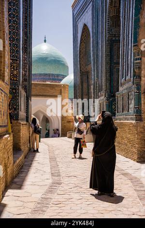 Samarkand, Usbekistan - 6. Juli 2024: Touristen fotografieren die Allee der Mausoleen in Shah-i-Zinda in Samarkand Stockfoto