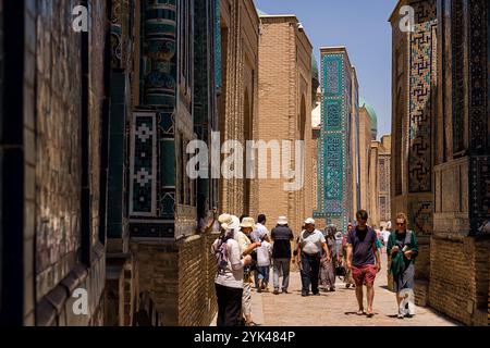 Samarkand, Usbekistan - 6. Juli 2024: Touristen und Pilger in der schmalen Straße von Shah-i-Zinda Mausoleen Stockfoto