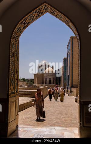 Samarkand, Usbekistan - 6. Juli 2024: Bogenförmiger Blick auf die Allee der Mausoleen bei Shah-i-Zinda in Samarkand mit ankommenden Pilgern Stockfoto