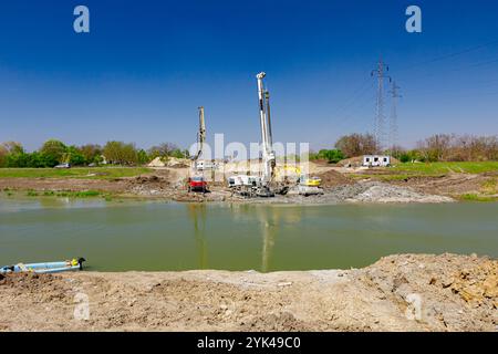 Industrielle Turmbohrmaschine, Stapelantrieb großer Ausrüstung zum Bohren in den Boden. Der Mischer mit Pumpenmaschine gießt frischen Beton auf lang Stockfoto