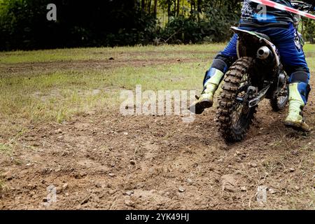 Nahaufnahme eines Dirt-Bike-Fahrers, der auf einer schroffen Strecke unterwegs ist und die Spannung und Intensität von Off-Road-Motorradsport und Abenteuersportarten erfasst Stockfoto