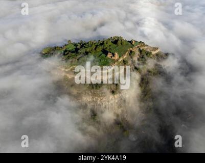 Blick aus der Vogelperspektive auf den Hügel Castell de Tona, umgeben von Nebel am Morgen in der Region Plana de Vic (Osona, Barcelona, ​​Catalonia, Spanien) Stockfoto