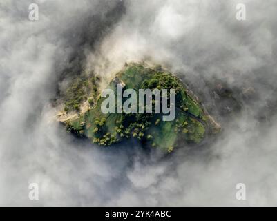 Blick aus der Vogelperspektive auf den Hügel Castell de Tona, umgeben von Nebel am Morgen in der Region Plana de Vic (Osona, Barcelona, ​​Catalonia, Spanien) Stockfoto