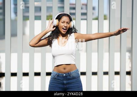 Eine Energiegeladene Junge Frau Genießt Ihre Lieblingsmusik, Während Sie Kopfhörer Trägt Stockfoto