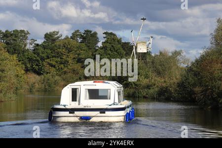 Ein Motorkreuzer, der im Herbst flussaufwärts auf dem River Ant auf den Norfolk Broads an der Boardman's Mill in How Hill, Ludham, Norfolk, England, Großbritannien, reiste. Stockfoto