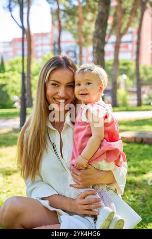Glückliche Mutter und kleines Mädchen spielen im Park. Stockfoto