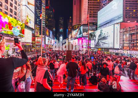 Überfüllter Times Square bei Nacht mit beleuchteten Reklametafeln, pulsierenden Lichtern und Touristen, die die lebhafte Atmosphäre in New York City einfangen. New York. USA. Stockfoto