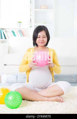 Asiatische schwangere Frau, die asiatische schwangere Frau mit Yoga-Ball ausübt Copyright: xZoonar.com/szefeix 1053985529st Stockfoto