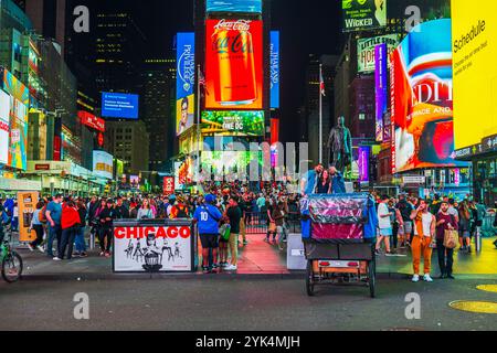 Lebendiger Times Square bei Nacht mit beleuchteten Plakaten, Touristenmassen und lebhaften Straßenszenen in New York City. New York. USA. Stockfoto