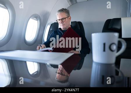 Premierminister Sir Keir Starmer arbeitet an Bord eines Regierungsflugzeugs, als er nach Rio de Janeiro in Brasilien reist, um am G20-Gipfel teilzunehmen. Bilddatum: Sonntag, 17. November 2024. Stockfoto