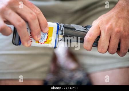 Ein Mann reinigt ein altes Gewehr sorgfältig mit Öl und Reinigungsgeräten und zeigt die Liebe zum Detail und die Handwerkskunst alter Schusswaffen. Stockfoto