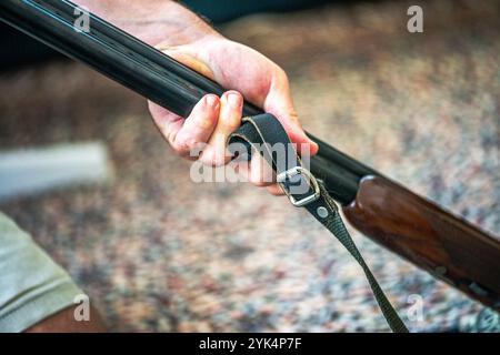 Ein Mann reinigt ein altes Gewehr sorgfältig mit Öl und Reinigungsgeräten und zeigt die Liebe zum Detail und die Handwerkskunst alter Schusswaffen. Stockfoto