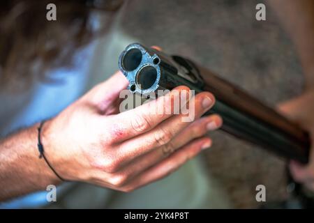 Ein Mann reinigt ein altes Gewehr sorgfältig mit Öl und Reinigungsgeräten und zeigt die Liebe zum Detail und die Handwerkskunst alter Schusswaffen. Stockfoto