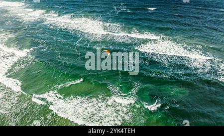 Ein Kitesurfer, der auf den großen Wellen auf dem Meer reitet. Erholung an der Ostsee, Tourismus in Polen. Stockfoto