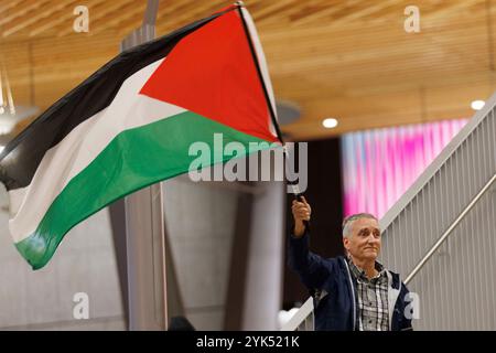 Ein Mann schwingt eine palästinensische Flagge. Diaa al-Haqq, 15 Jahre alt, ein schwer verwundeter palästinensischer Junge, kam am 16. November 2024 mit seiner Schwester Ayah in Portland, Oregon, nach einer viertägigen Wanderung von Gaza an, um medizinische Versorgung und prothetische Unterstützung zu erhalten, nachdem ihn ein israelischer Explosionsschlag beide Arme gekostet hatte. Er wird bei einer lokalen Familie bleiben, während er im Shriner's Hospital versorgt wird. (Foto: John Rudoff/SIPA USA) Stockfoto