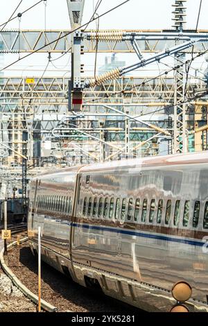 Japanische E7-Serie Shinkansen, Hochgeschwindigkeitszug, kommt an einem sonnigen Tag in den Bahnhof Tokio. Komprimierte perspektivische Ansicht der Wagen des Zuges Stockfoto