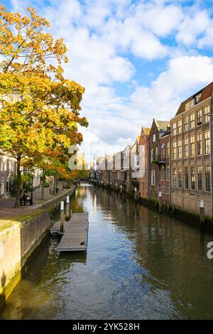 Malerische Aussicht auf Häuser entlang eines Kanals in der historischen Stadt Dordrecht, Niederlande im Herbst. Stockfoto