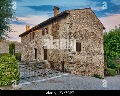 Italienisches mittelalterliches Dorf, Castellaro Lagusello in der Nähe von Mantua. Ein rustikales altes Haus steht friedlich umgeben von Grün in der Abenddämmerung. Stockfoto