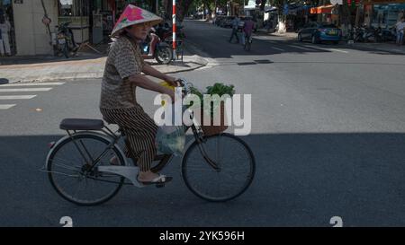 Danang, Vietnam 2. Mai 2024: Unbekannte Frau nach dem Einkaufen und mit dem Fahrrad in der Nähe des Han Markts in Vietnam nach Hause fahren. Es ist der größte lokale Feuchtmarkt i Stockfoto