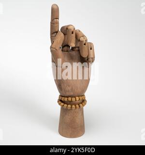 Hölzerne Hand mit zwei hölzernen Armbändern auf weißem Hintergrund Stockfoto