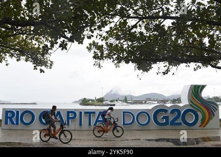 (241117) -- RIO DE JANEIRO, 17. November 2024 (Xinhua) -- Menschen fahren mit dem Fahrrad vorbei an einem G20-Logo in der Nähe des 19. G20-Gipfels in Rio de Janeiro, Brasilien, 16. November 2024. Der 19. G20-Gipfel ist vom 18. Bis 19. November in Rio de Janeiro geplant. (Foto: Lucio Tavora/Xinhua) Stockfoto