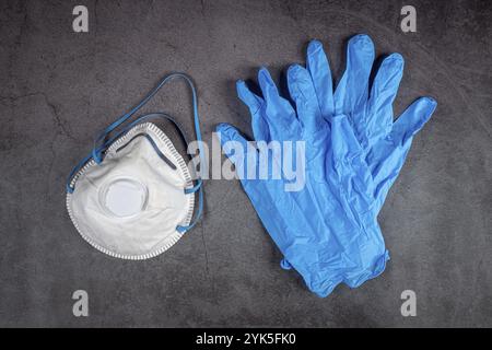 Atemschutzmaske und Handschuhe auf schwarzer Rückseite. Maskenschutz gegen Verschmutzung, Virus, Grippe und Coronavirus 2019-nCoV Stockfoto